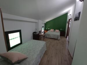 1 dormitorio con 2 camas y pared verde en La Cordobesa, en Priego de Córdoba