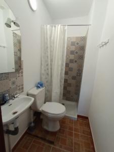 a bathroom with a white toilet and a sink at La Cordobesa in Priego de Córdoba