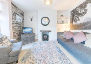 sala de estar con sofá y chimenea en Withesike, Derwent House, en Keswick