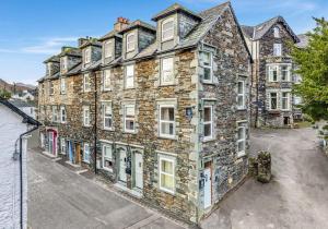 un gran edificio de piedra con ventanas blancas en una calle en Withesike, Derwent House, en Keswick