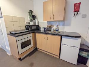 a small kitchen with a sink and a microwave at 1 Bedroom Studio in a Supurb Area of Cardiff in Cardiff