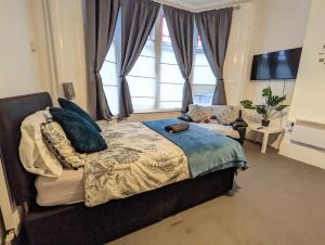 a bedroom with a bed and a large window at 1 Bedroom Studio in a Supurb Area of Cardiff in Cardiff