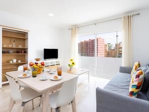 Lightbooking Candelaria Tenerife في Araya: غرفة معيشة بيضاء مع طاولة وأريكة