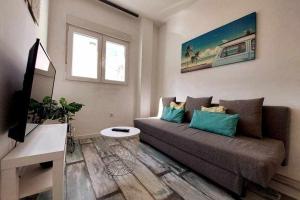 un soggiorno con divano e TV di Bonito apartamento en 2º línea de playa & parking a Málaga