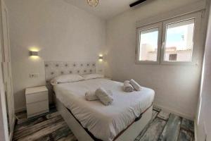 una camera da letto con un letto e due asciugamani di Bonito apartamento en 2º línea de playa & parking a Málaga