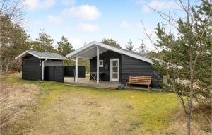 a black cabin with a porch and a bench at 2 Bedroom Beautiful Home In Thisted in Thisted