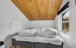 2 Bedroom Beautiful Home In Thisted في ثيستد: سرير في غرفة ذات سقف خشبي