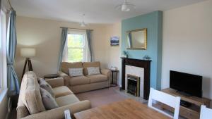 sala de estar con sofá y chimenea en Skiddaw. 20 Greta Grove House, en Keswick