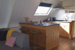 a kitchen with a counter with a sink and a window at De hoftuin Ilpendam appartement in Ilpendam