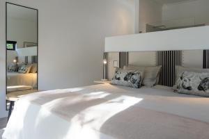 a white bedroom with a large white bed with pillows at Views over Wilderness in Wilderness