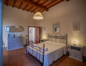1 dormitorio con cama, tocador y espejo en B&B La Torre - Fattoria di Larniano, en San Gimignano