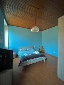 a bedroom with a bed and a blue wall at La Locanda dell'Oreste in Dizzasco