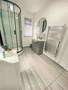 La salle de bains est pourvue d'une douche, d'un lavabo et d'un miroir. dans l'établissement Gatwick Studio, à Horley