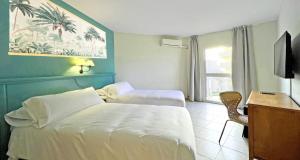 a hotel room with two beds and a desk and a window at Moon Dreams Fuengirola in Fuengirola