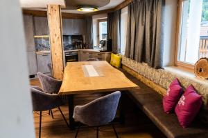 uma sala de jantar com uma mesa de madeira e cadeiras em Edelweiss Chalet im Sommer inklusive Super Sommer Card em Ladis