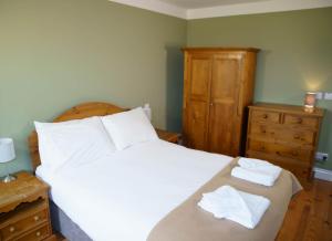 ein Schlafzimmer mit einem Bett mit zwei Handtüchern darauf in der Unterkunft Dingle CY - 3 Bed NO 12 in Dingle