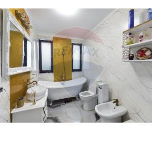 a bathroom with two toilets and a tub and a sink at RAX Panoramic House in Feleacu
