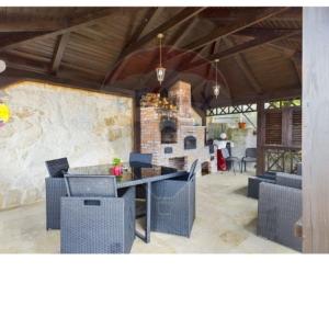 a patio with chairs and a table and a stone wall at RAX Panoramic House in Feleacu