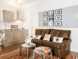 ein Wohnzimmer mit einem braunen Sofa und einem Tisch in der Unterkunft Apartamentos Los Venerables in Sevilla
