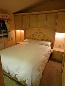 a bedroom with a large bed with white sheets at Stunning Holiday Home Whithorn3 in Newton Stewart