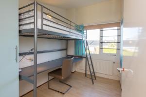 Zimmer mit einem Etagenbett, einem Schreibtisch und einem Stuhl in der Unterkunft Lepelblad 6 in Nieuwvliet
