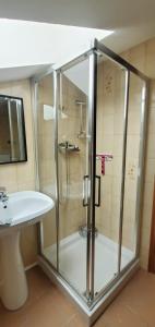La salle de bains est pourvue d'une douche et d'un lavabo. dans l'établissement Mansarda Via Chanoux, à Saint-Vincent