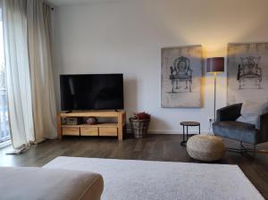 a living room with a flat screen tv and a couch at 5-Sterne-City Apartment Rendsburg in Rendsburg