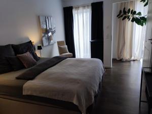 5-Sterne-City Apartment Rendsburg في ريندسبورغ: غرفة نوم بسرير كبير وكرسي