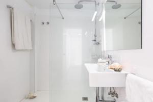 un bagno bianco con lavandino e doccia di El Guix de la Meda a Torroella de Montgrí Altre 15 foto