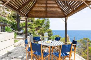 un tavolo e sedie sotto un pergolato con vista sull'oceano di El Guix de la Meda a Torroella de Montgrí