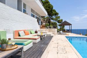 un patio con divano e tavoli accanto alla piscina di El Guix de la Meda a Torroella de Montgrí