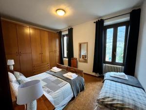 a bedroom with two beds and a lamp at La Locanda dell'Oreste in Dizzasco +29 photos