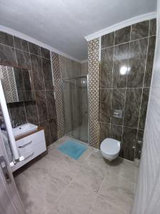 een badkamer met een douche, een toilet en een wastafel bij Erbay suit in Trabzon
