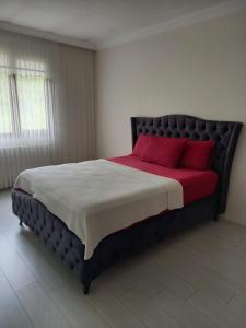 een slaapkamer met een groot bed met rode kussens bij Erbay suit in Trabzon