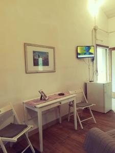 Habitación con mesa con sillas y teléfono. en Agriturismo Botro en Pulicciano