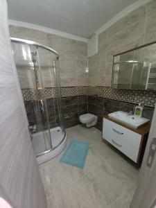 een badkamer met een douche, een toilet en een wastafel bij Erbay suit in Trabzon