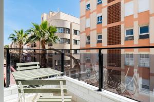 einen Balkon mit einer Bank und Blick auf ein Gebäude in der Unterkunft Sunrise Center Suites in Torrevieja