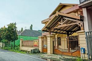 a house with an awning on the side of it at SPOT ON 92450 Homestay Simpang Panji Suroso Syariah in Malang