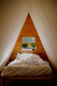塔里法的住宿－TAIGA Tarifa，木制客房的一张床位,设有窗户