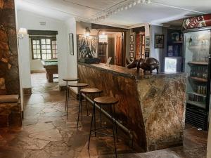 un bar con taburetes en una habitación con mesa en Fika Lodge en Mkushi