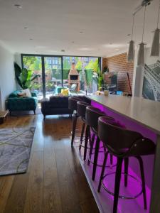 una sala de estar con un bar con taburetes en Jubilee house, en Londres