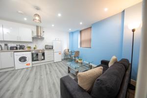a living room with a couch and a kitchen at Charming 1BR in Stockport Center in Stockport