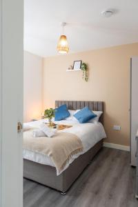 a bedroom with a large bed with blue pillows at Charming 1BR in Stockport Center in Stockport