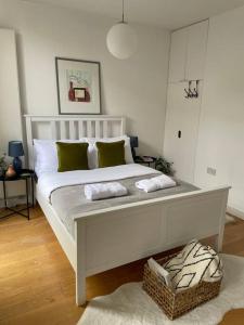 a white bed with two pillows on it in a room at Shoreditch Cosy Flat, next to Van Gogh exhibition in London