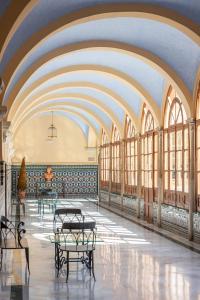 a hallway with tables and windows in a building at Hotel Macià Monasterio de los Basilios in Granada