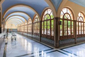 a hallway with large windows in a building at Hotel Macià Monasterio de los Basilios in Granada