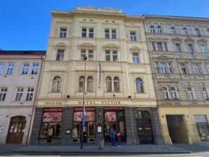 a large building with people standing in front of it at Hotel Victor in Prague