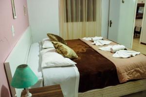 una camera da letto con un grande letto con cuscini sopra di Pousada Cantinho a Gramado
