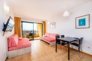 uma sala de estar com um sofá e uma mesa em Apto con Terraza 202 em Cala Millor