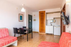 uma sala de estar com um sofá vermelho e uma mesa em Apto con Terraza 202 em Cala Millor